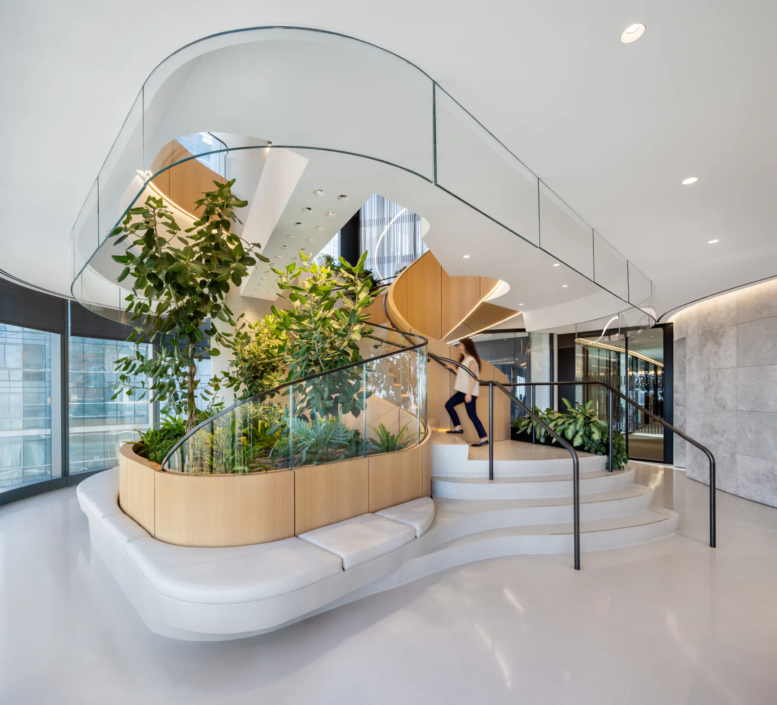 Biophilic office lobby with a planted spiral staircase and integrated greenery